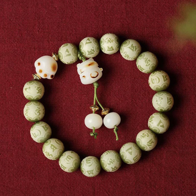 Bodhi Om Mani Padme Hum Armband mit grünen Perlen und weißen Akzenten.