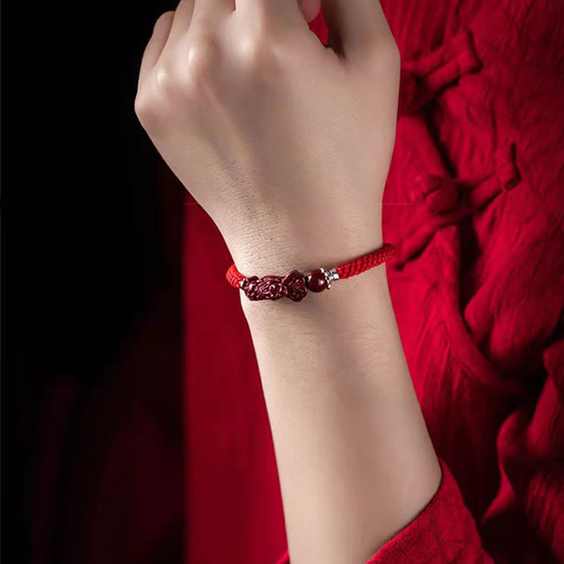 Armband Zinnober Pixiu am Handgelenk getragen rotes elastisches Armband Glück Wohlstand