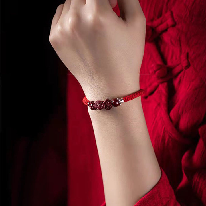 Armband Zinnober Pixiu am Handgelenk getragen rotes elastisches Armband Glück Wohlstand