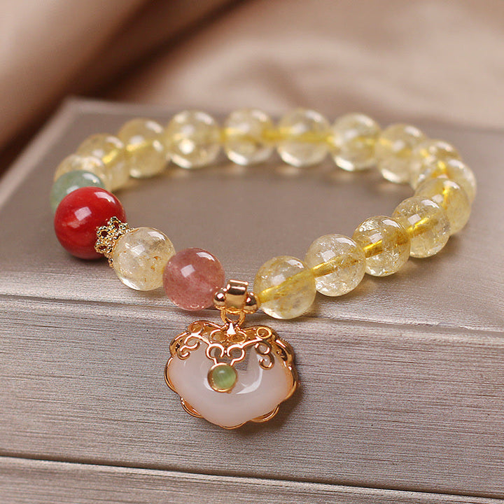 Armband Erdbeerquarz Weiße Jade auf Holzoberfläche mit Anhänger