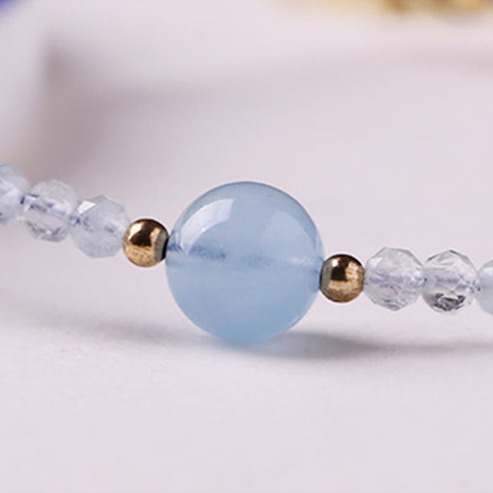 Armband Aquamarin Frieden Energie facettierte Perlen goldene Akzente Nahaufnahme Handgelenk