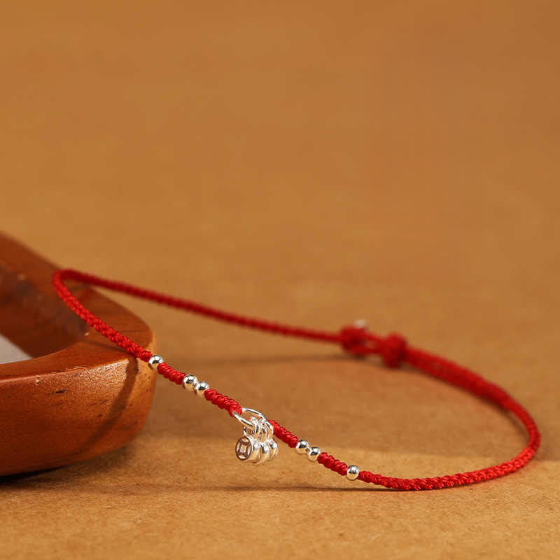 Rotes Armband 925 Silber Kupfer Schutz Stärke mit Silberperlen auf Holz