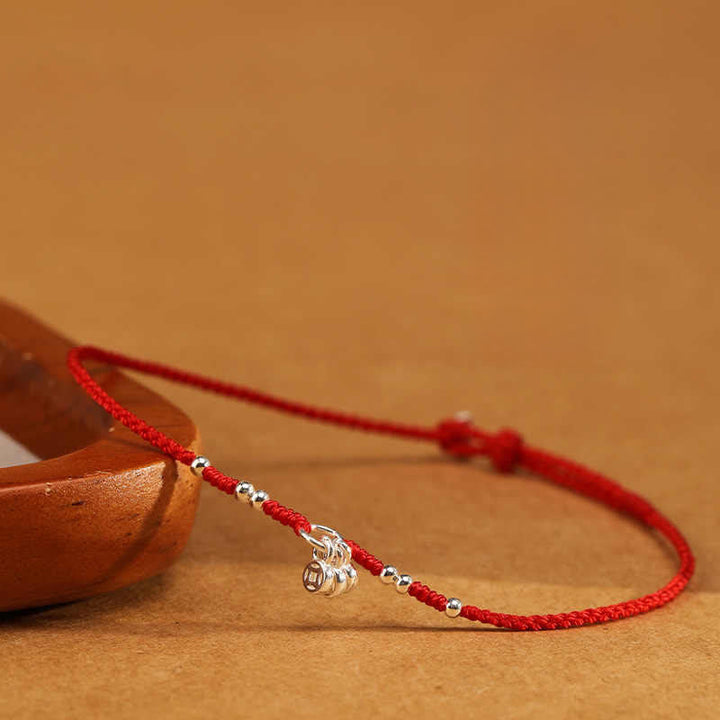Rotes Armband 925 Silber Kupfer Schutz Stärke mit Silberperlen auf Holz