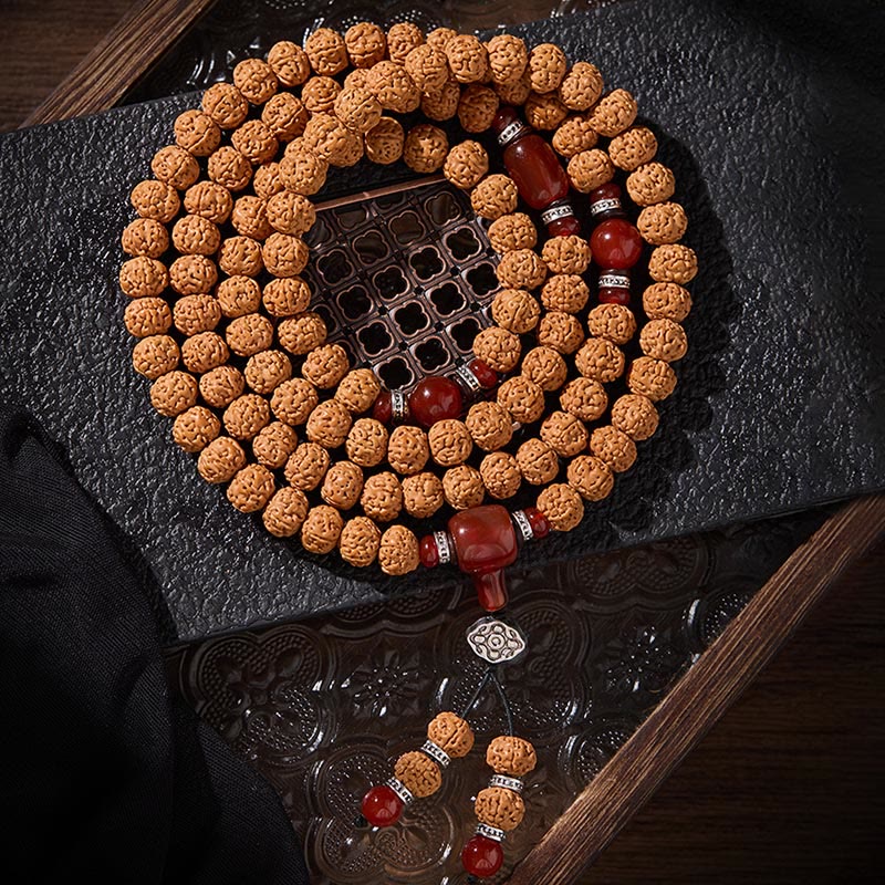 Armband Bodhi-Samen Dzi-Perle – Glück mit roten Achat-Perlen auf dunklem Holz