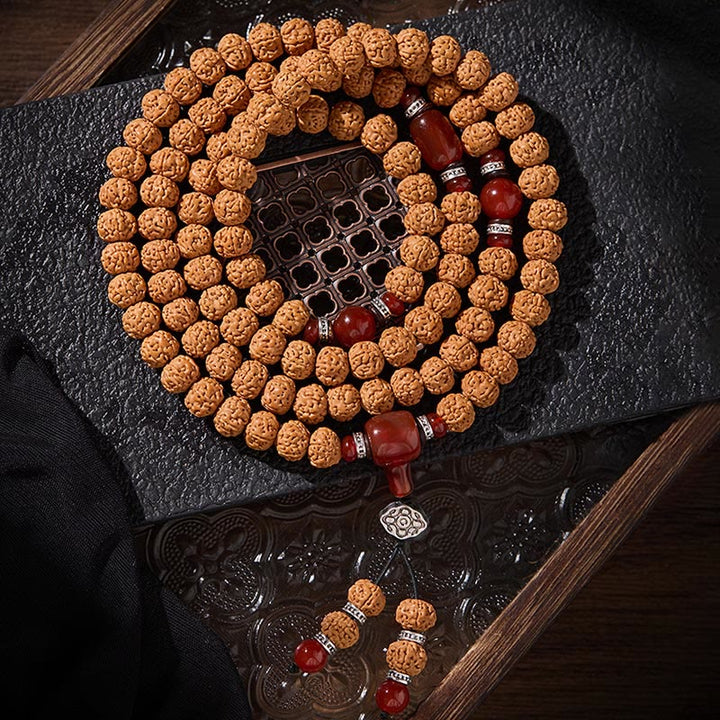 Armband Bodhi-Samen Dzi-Perle – Glück mit roten Achat-Perlen auf dunklem Holz