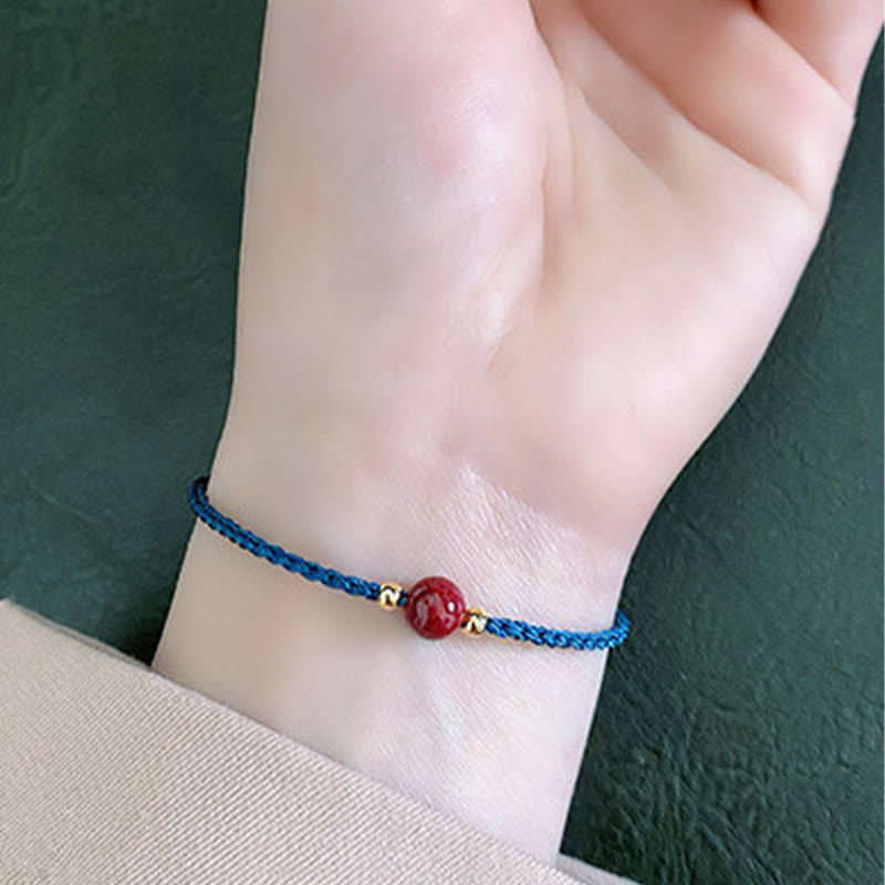 Armband Zinnober Rotes Band geflochten am Handgelenk getragen Schutz Glück Fengshui
