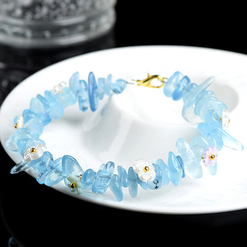 Armband Erdbeerquarz Aquamarin mit Blütenperlen elegant präsentiert auf weißer Schale