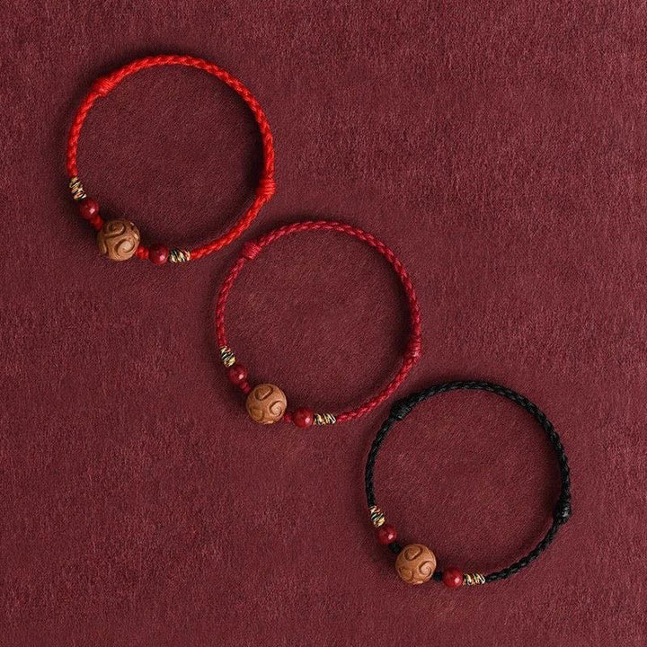 Armband Pfirsichholz Zinnober Glück geflochten rot schwarz Schutz Handgelenk