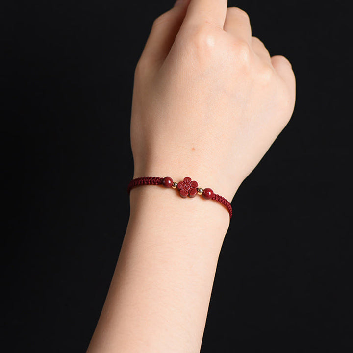 Armband Zinnober Kleeblatt Blume rote Kordel am Handgelenk getragen Liebe Segen Energie