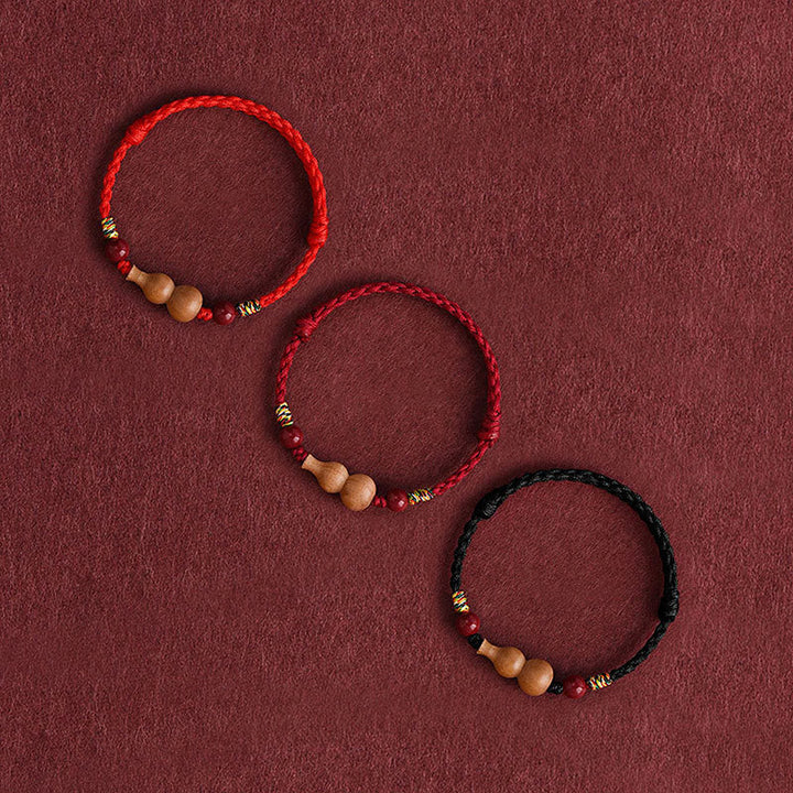 Armband Pfirsichholz Glück Wohlstand Kalebasse geflochten rot schwarz Handgelenk Schutz