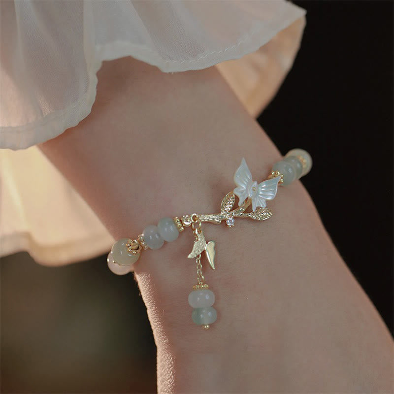 Armband Jade Schmetterling Wohlstand Energie am Handgelenk mit goldenen Details getragen