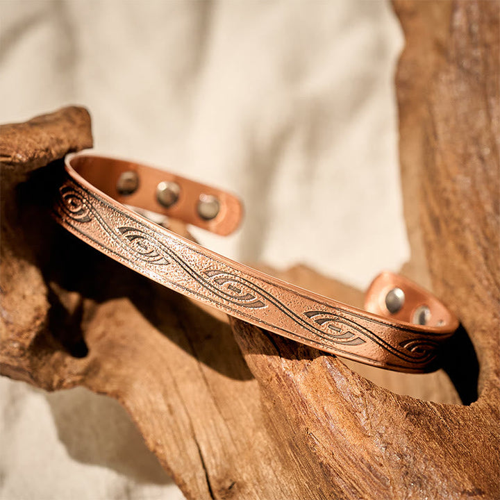 Armband Kupfer Spiral – Balance mit Magneten auf Holz Naturfoto