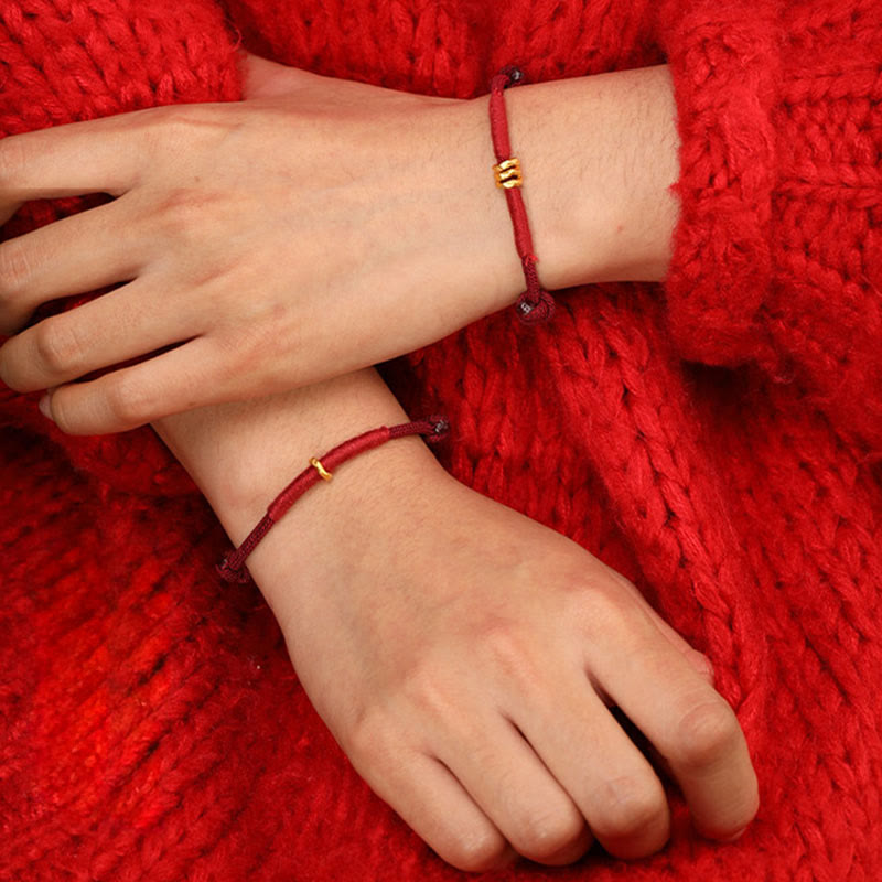 Armband 999 Gold Geflochten Rot – Glück am Handgelenk vor rotem Pullover