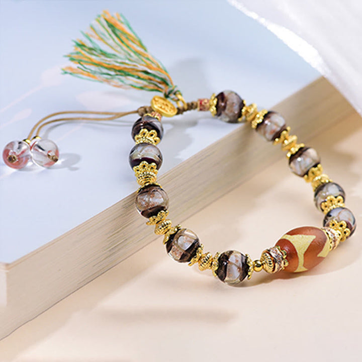 Armband Liuli – Segen mit Dzi Perle Quaste goldene Akzente Handgelenk