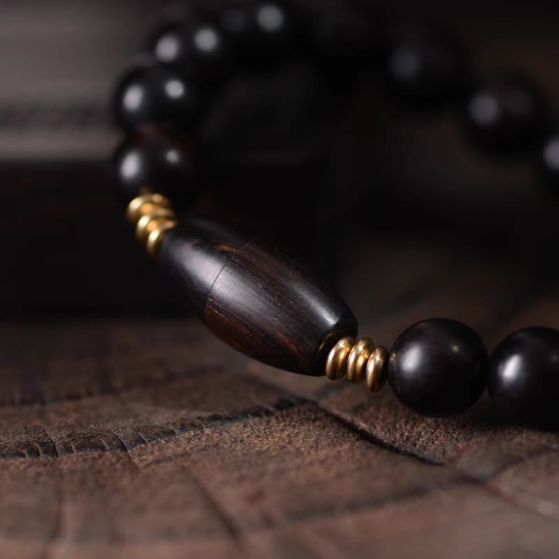 Armband Ebenholz Schutz Segen Messingperlen dunkles Holz Handgelenk Nahaufnahme