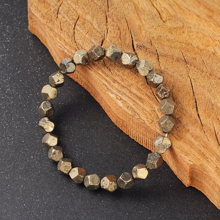 Armband Pyrit Buddha Schutz Vertrauen facettierte Perlen auf Holz