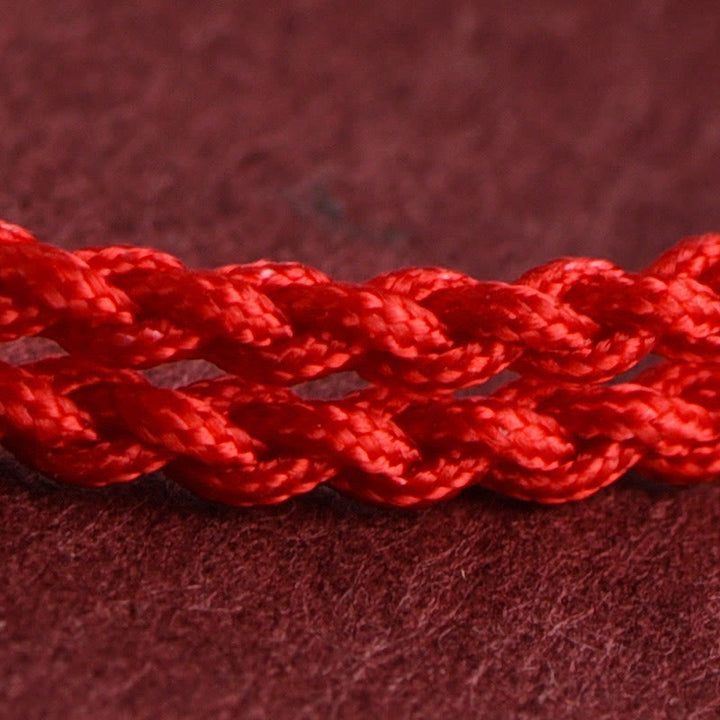 Armband Pfirsichholz – Glück & Wohlstand rote geflochtene Kordel Nahaufnahme Schutz