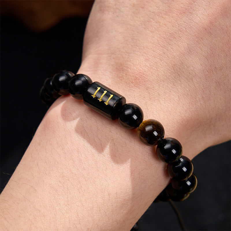 Armband Schwarzer Obsidian Tigerauge Stärke Segen am Handgelenk getragen Nahaufnahme