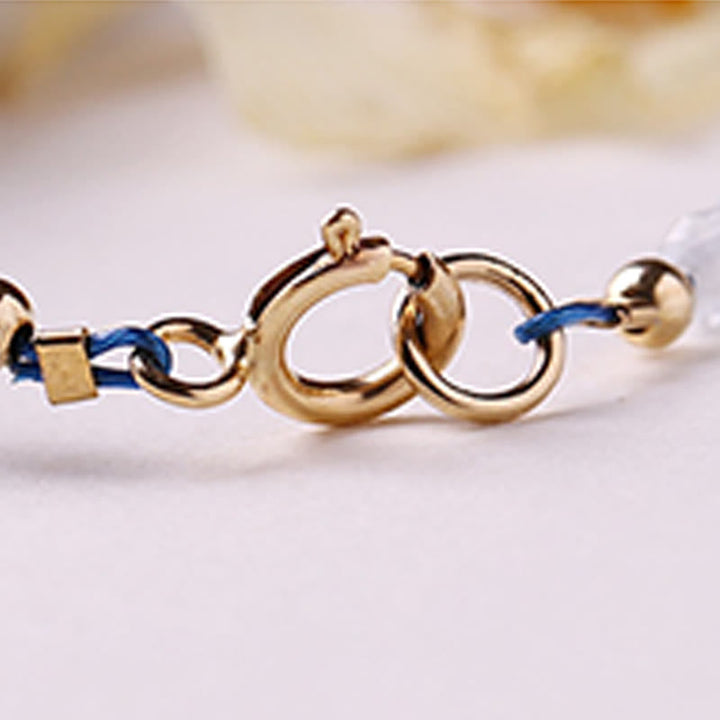 Armband Aquamarin Frieden Energie goldener Verschluss blaue Schnur Detailaufnahme Handgelenkschmuck