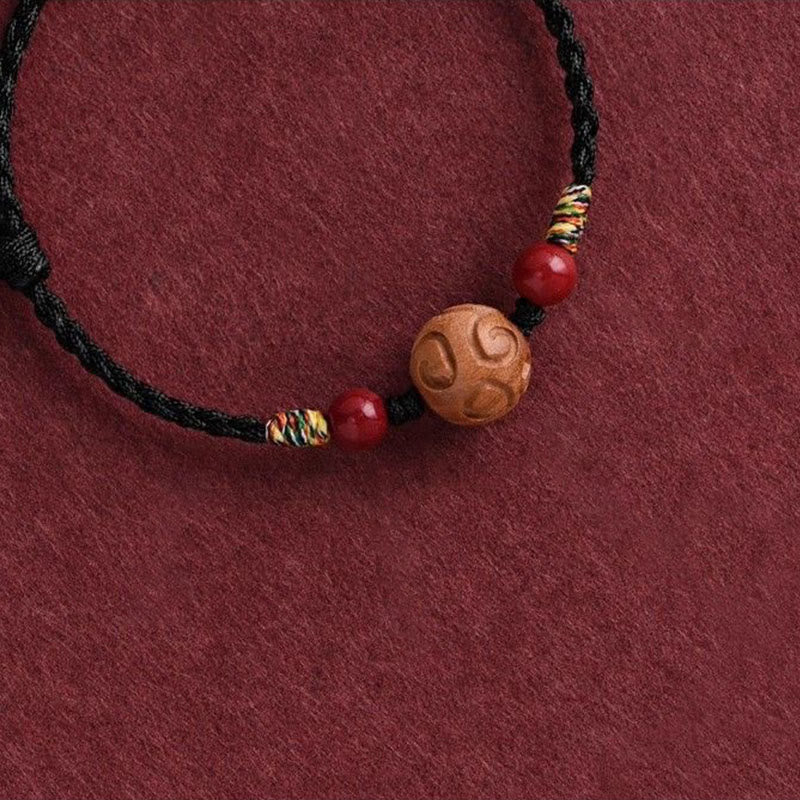Armband Pfirsichholz Zinnober Glück geflochten schwarz rote Perlen Handgelenk