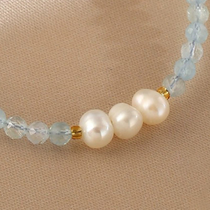 Armband Aquamarin Perle mit Süßwasserperlen und goldenen Akzenten elegant am Handgelenk