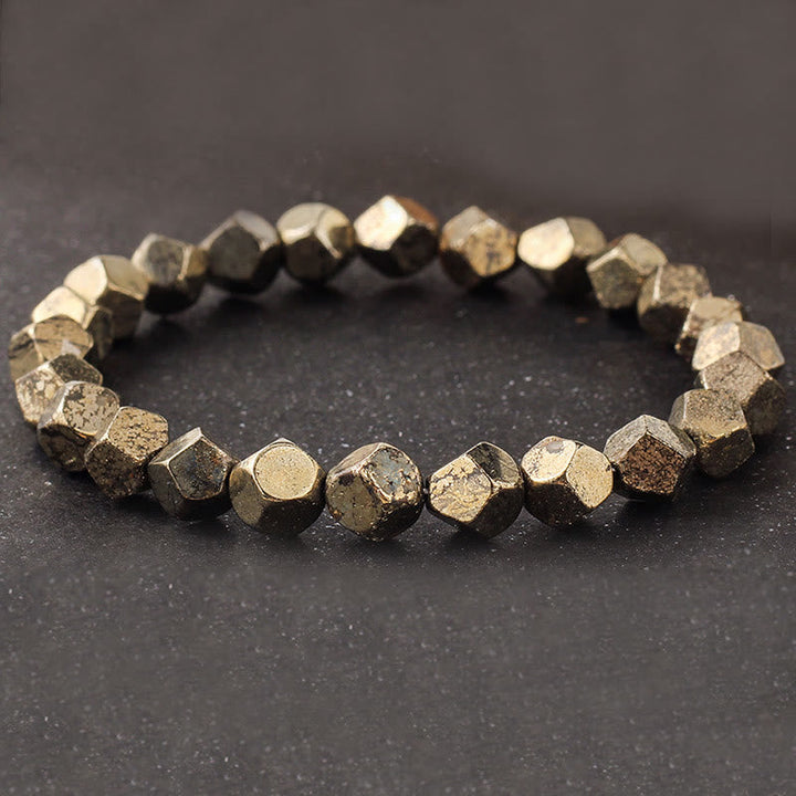 Armband Pyrit Buddha Schutz Vertrauen facettierte Perlen goldener Glanz Steinhintergrund