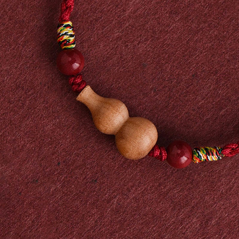 Armband Pfirsichholz Glück Wohlstand Kalebasse Anhänger rotes geflochtenes Seil Detail