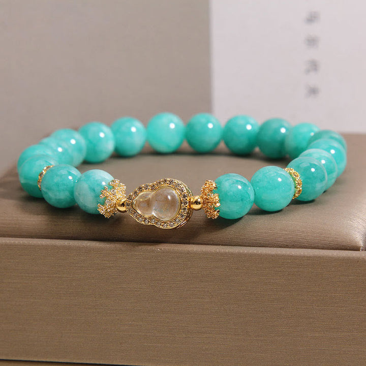 Armband Amazonit – Heilung & Selbstvertrauen mit goldener Buddha Perle auf Schachtel