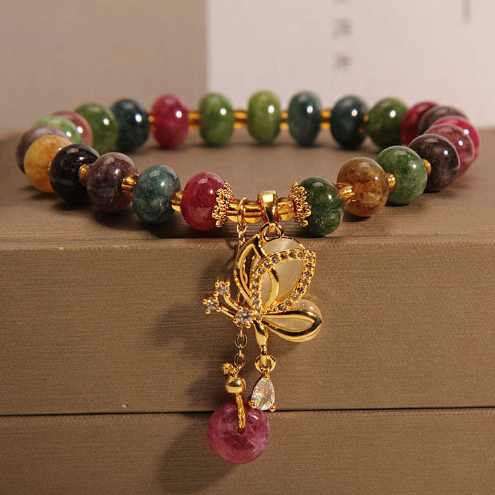 Armband Schmetterling mit bunten Edelsteinen und goldenem Anhänger elegant.