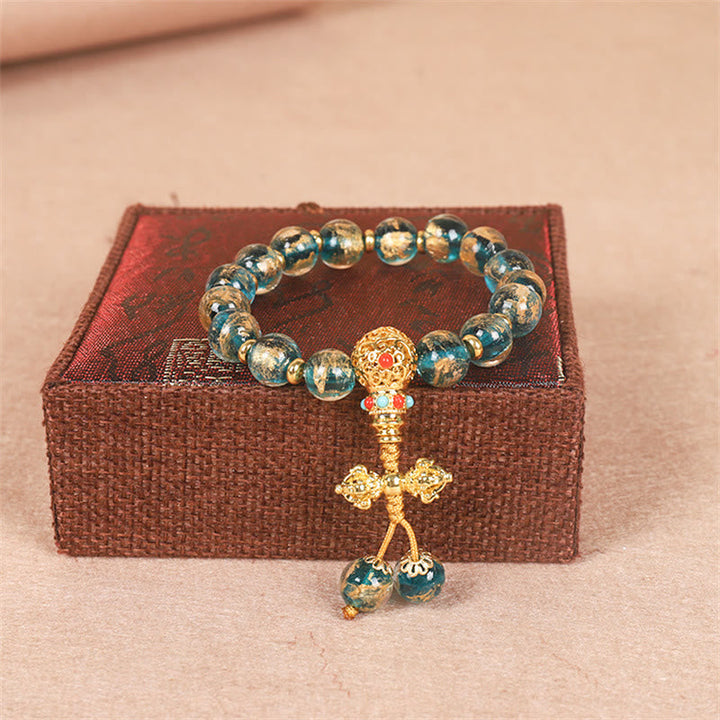 Armband Tibet Goldverschlingendes Wesen Family Stärke mit blaugrünen Perlen.