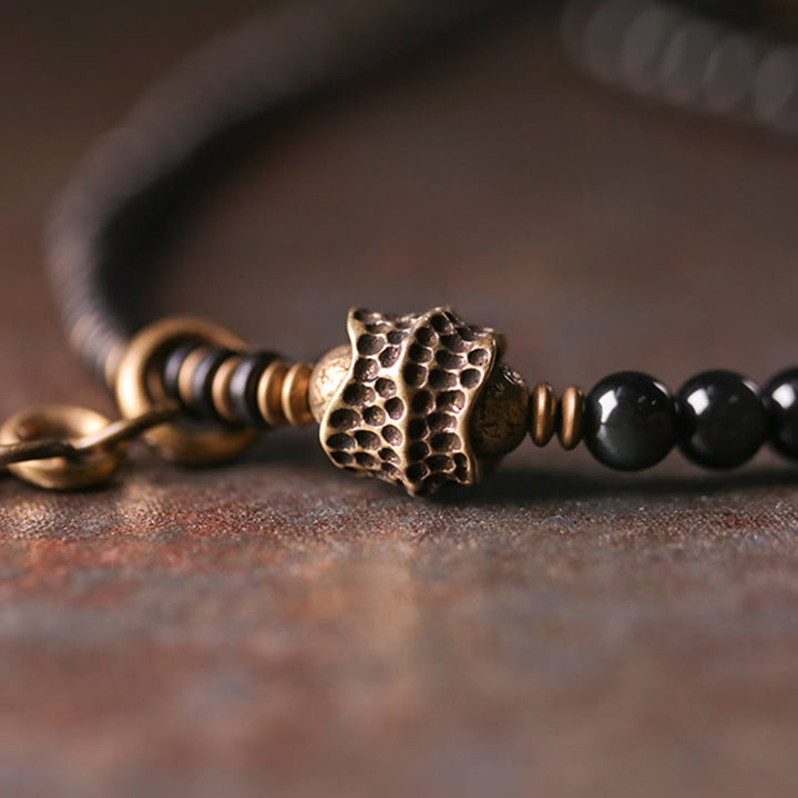 Armband Obsidian Kupfer mit schwarzen Perlen und Metallverzierungen elegant.