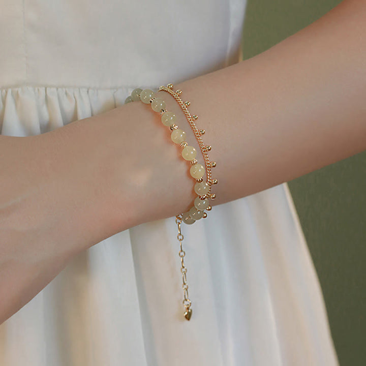 Jade Armband am Handgelenk, goldene Perlen, elegantes Glück Wohlstand Harmonie.