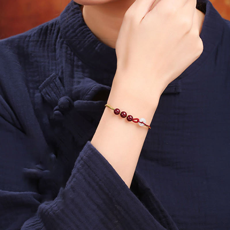 Armband Zinnober Jade am Handgelenk mit roten Perlen elegant getragen