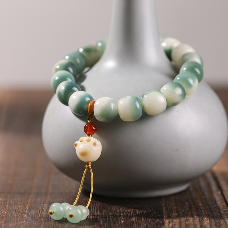 Bodhi Katze Armband mit grünen Perlen und Anhänger elegant präsentiert.