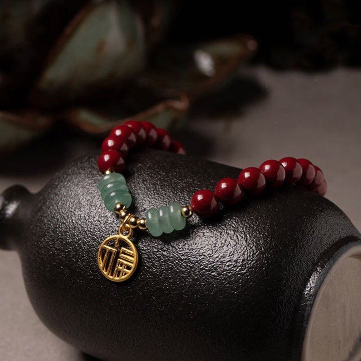 Armband Grüner Aventurin Zinnober auf schwarzer Keramik-Schale, rote Perlen Glück Segen.