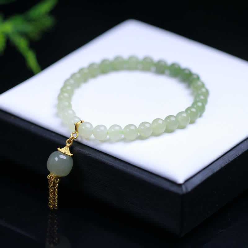 Hellgrünes Jade Armband mit goldenem Anhänger Quaste elegant.