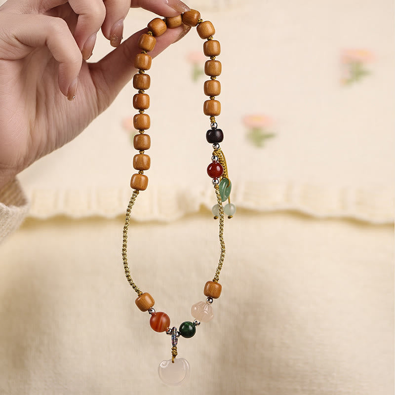 Armband Sandelholz – Frieden & Energie mit Natursteinen in Hand gehalten