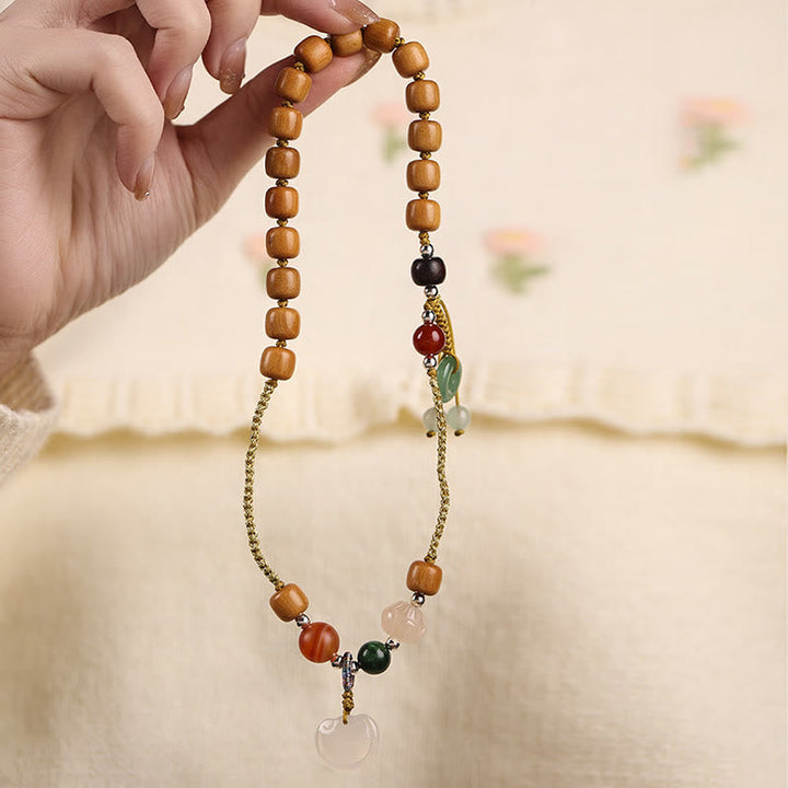 Armband Sandelholz – Frieden & Energie mit Natursteinen in Hand gehalten