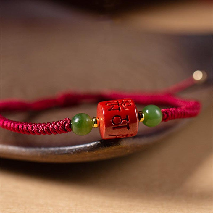 Rotes Zinnober Armband mit grünen Jadekugeln elastisch getragen.