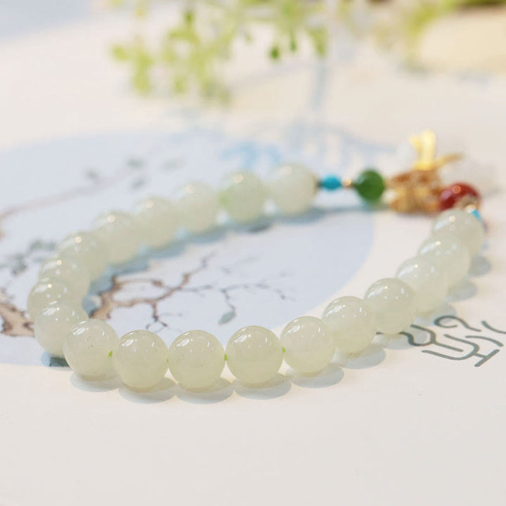 Armband Weiße Jade – Segen mit glänzenden Perlen elastisch getragen