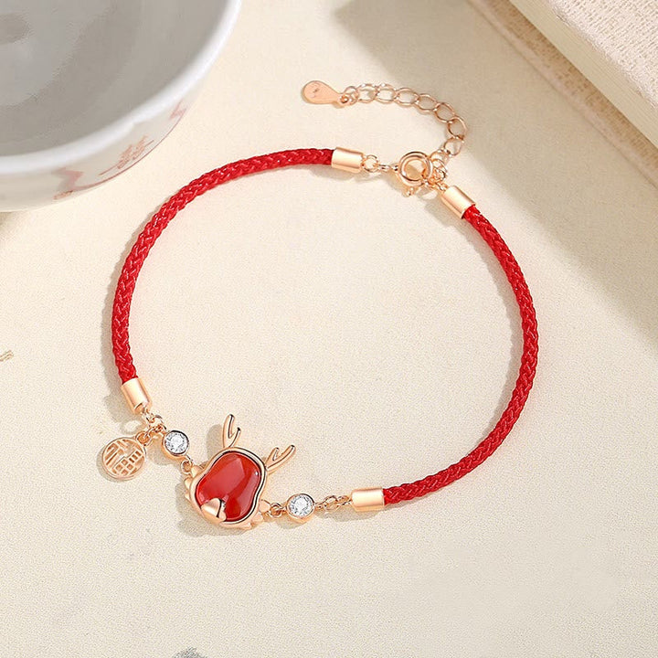 Rotes Armband mit Achat-Anhänger und rosegoldfarbenen Verschlüssen elegant präsentiert.