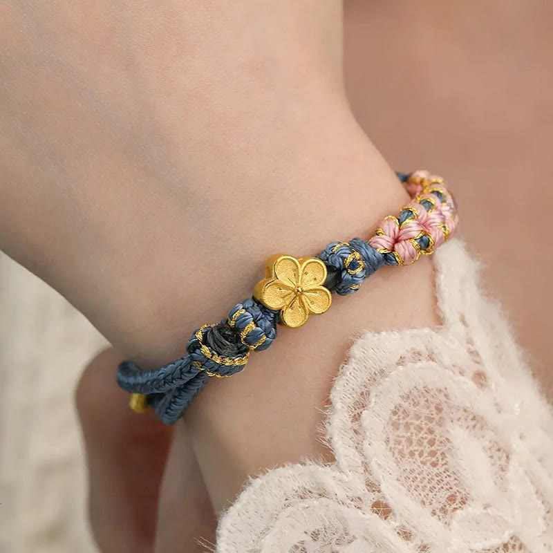 Armband Pfirsichblüte – Wohlstand goldene Blume blaues Seidenband Handgelenk