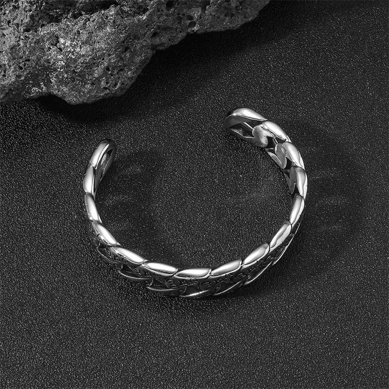 Silbernes Armband Om Mani Padme Hum am schwarzen Strand mit Wellen.