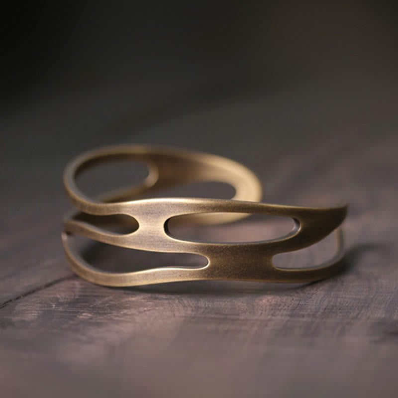 Kupfer Armband mit offenen Oval-Motiven auf Holzoberfläche elegant.