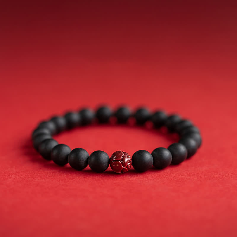 Armband Zinnober Lotus – Heilung schwarze Perlen rote Blüte rot Hintergrund