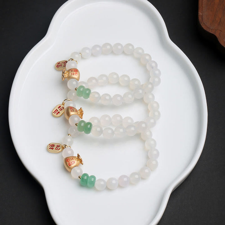 Weiß Jade Armband mit grünen Fu-Zeichen Charms elegant präsentiert.