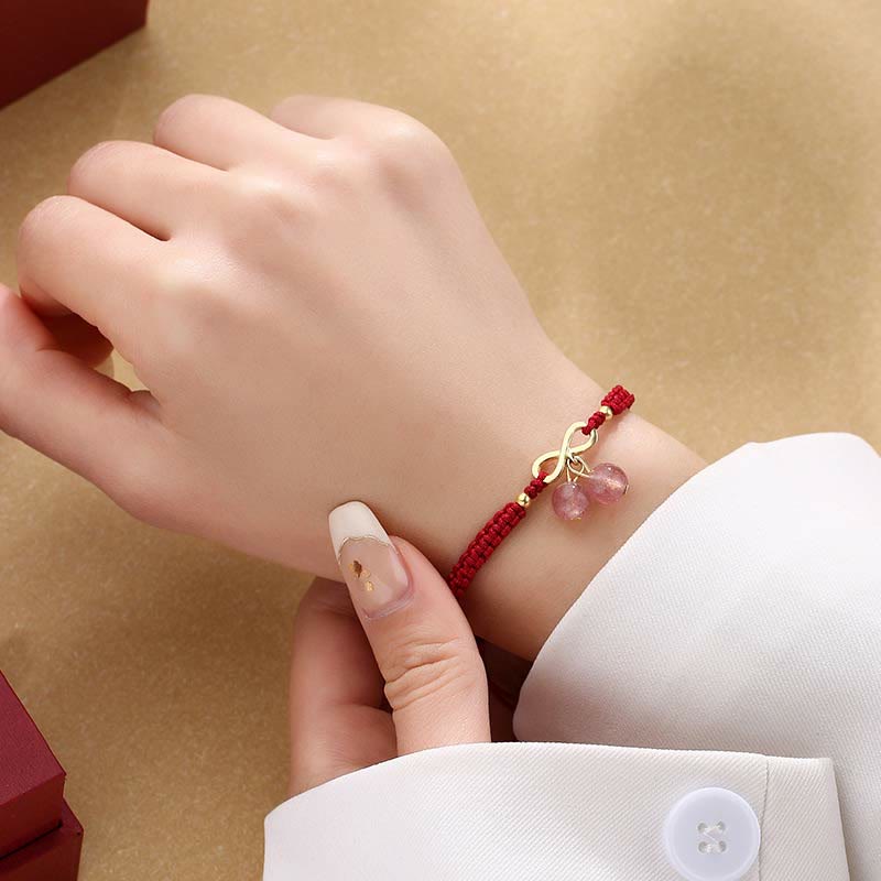Rotes Armband Erdbeerquarz Kristall am Handgelenk mit eleganter Schleife.