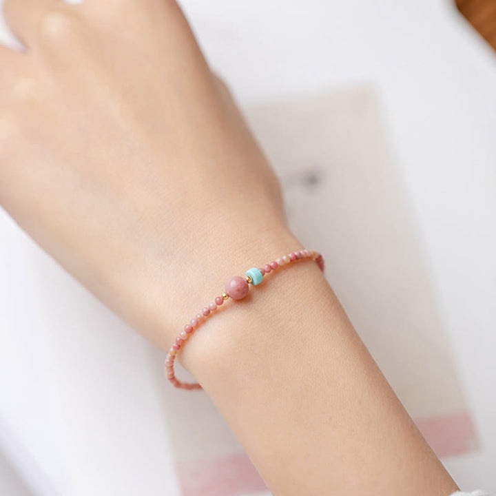Rosenquarz Armband – Energie mit türkisen Perlen am Handgelenk getragen
