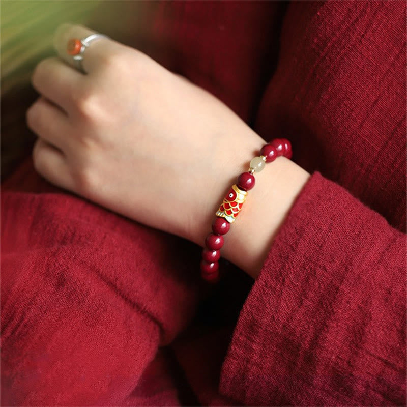 Rotes Armband mit Jade Koi Fisch Perlen am Handgelenk getragen