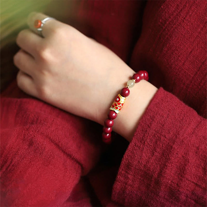 Rotes Armband mit Jade Koi Fisch Perlen am Handgelenk getragen